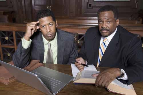 Lawyers sit in a courtroom